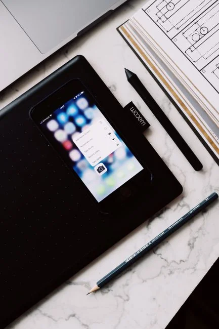 A sleek office desk setup featuring Apple devices: iMac, MacBook, and iPad.