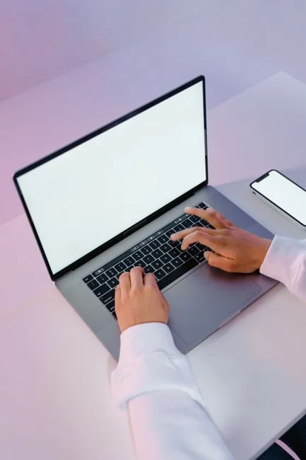 Un espace de travail moderne avec un ordinateur portable, une tablette et des smartphones, parfait pour les secteurs technologiques et les freelances.
